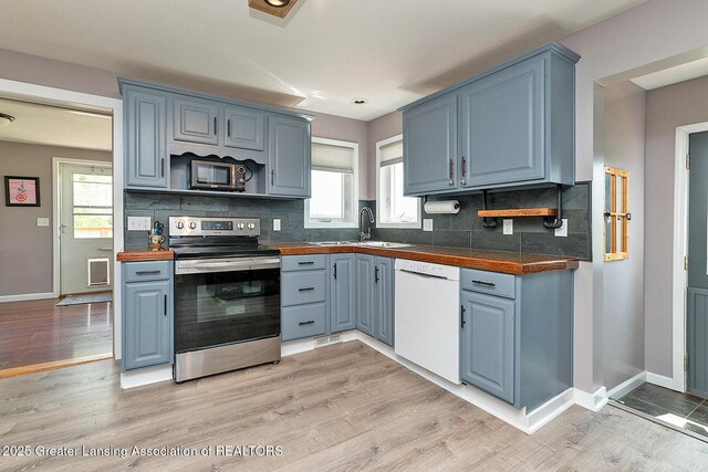 kitchen with blue cabinetry, white dishwasher, light wood-type flooring, a sink, and stainless steel electric stove