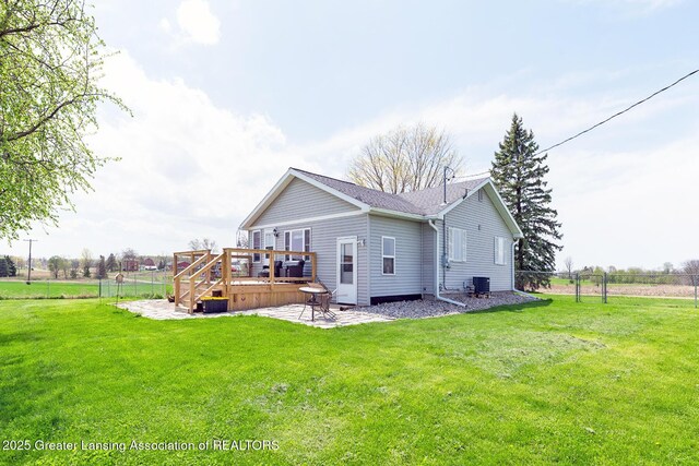 back of property with fence, a patio, a lawn, and a deck
