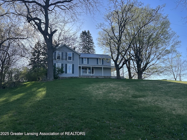 traditional-style house with covered porch and a front lawn