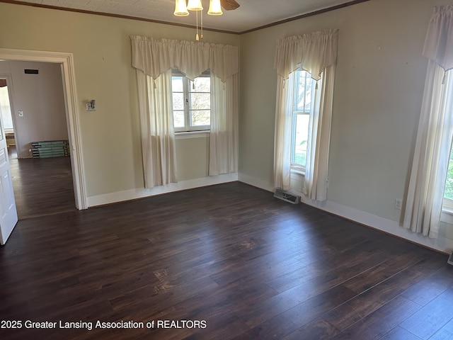 unfurnished dining area with crown molding, visible vents, baseboards, ceiling fan, and dark wood-style floors