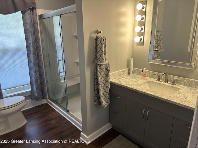 bathroom with vanity, a shower stall, toilet, and wood finished floors