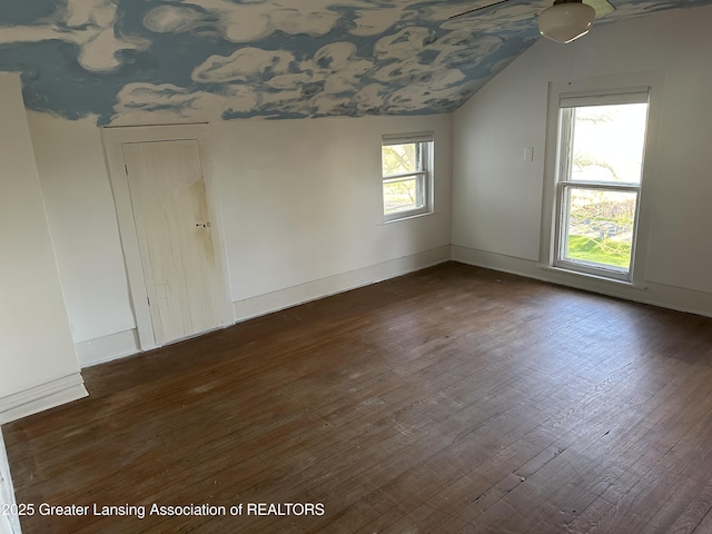 unfurnished room featuring baseboards, dark wood-style flooring, and lofted ceiling