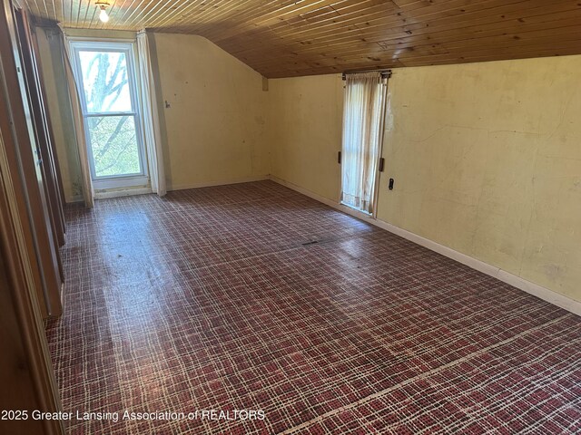 additional living space with baseboards, vaulted ceiling, and wooden ceiling