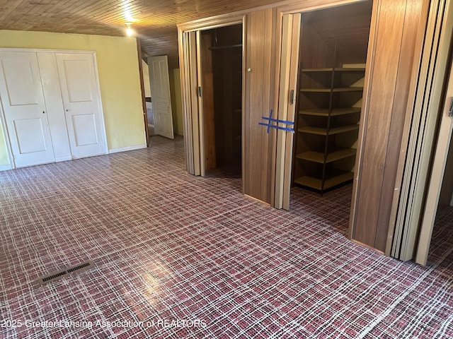 interior space with baseboards and wooden ceiling