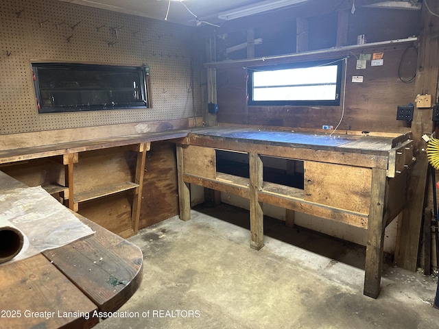 miscellaneous room featuring a workshop area and concrete floors