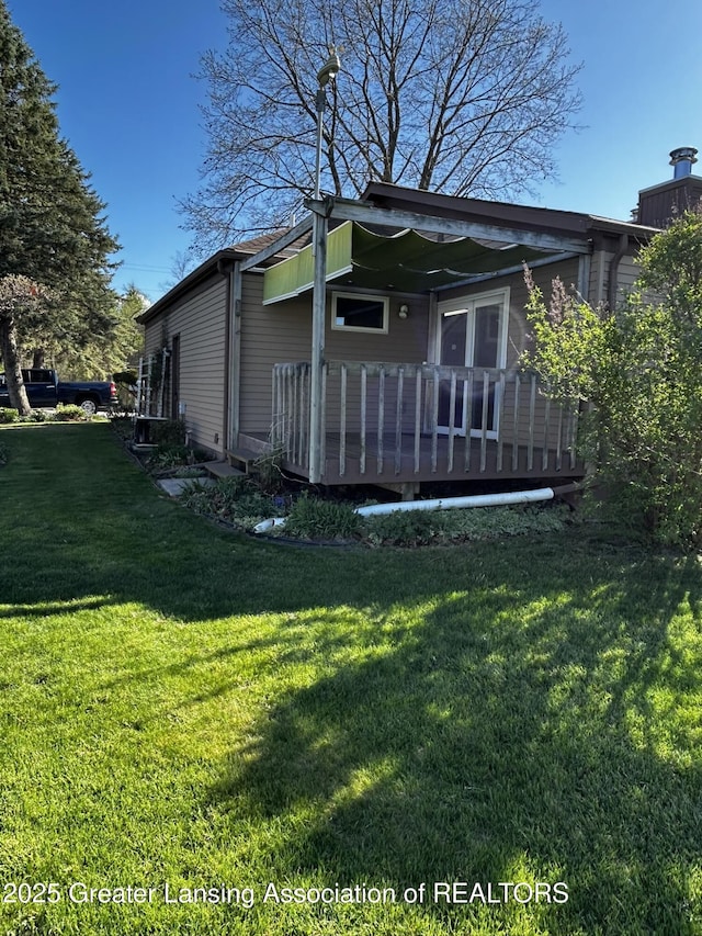 9466 W Grand River Ave, Grand Ledge, MI 48837 - exterior space with a wooden deck and a yard