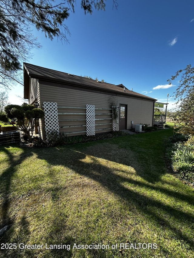 9466 W Grand River Ave, Grand Ledge, MI 48837 - back of house featuring central AC unit and a yard