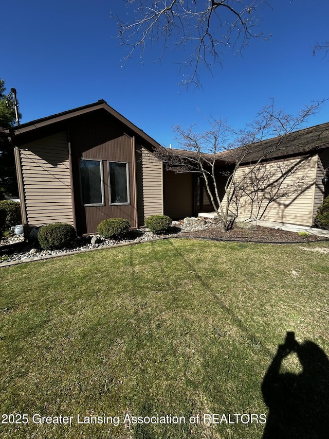 9466 W Grand River Ave, Grand Ledge, MI 48837 - view of front of house featuring a garage and a front lawn