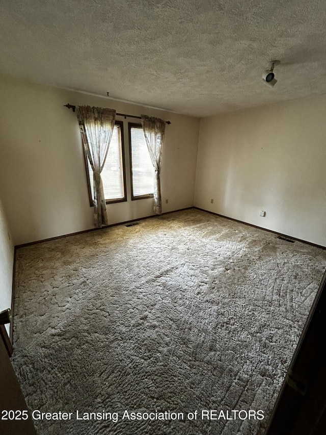 9466 W Grand River Ave, Grand Ledge, MI 48837 - spare room with baseboards, carpet flooring, a textured ceiling, and visible vents