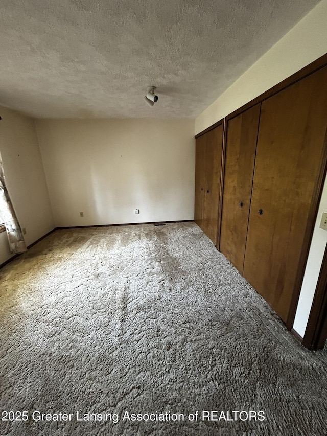 9466 W Grand River Ave, Grand Ledge, MI 48837 - unfurnished bedroom with carpet flooring and a textured ceiling