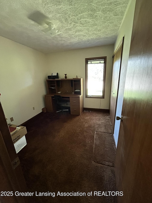 9466 W Grand River Ave, Grand Ledge, MI 48837 - unfurnished office featuring baseboards, a textured ceiling, and dark carpet