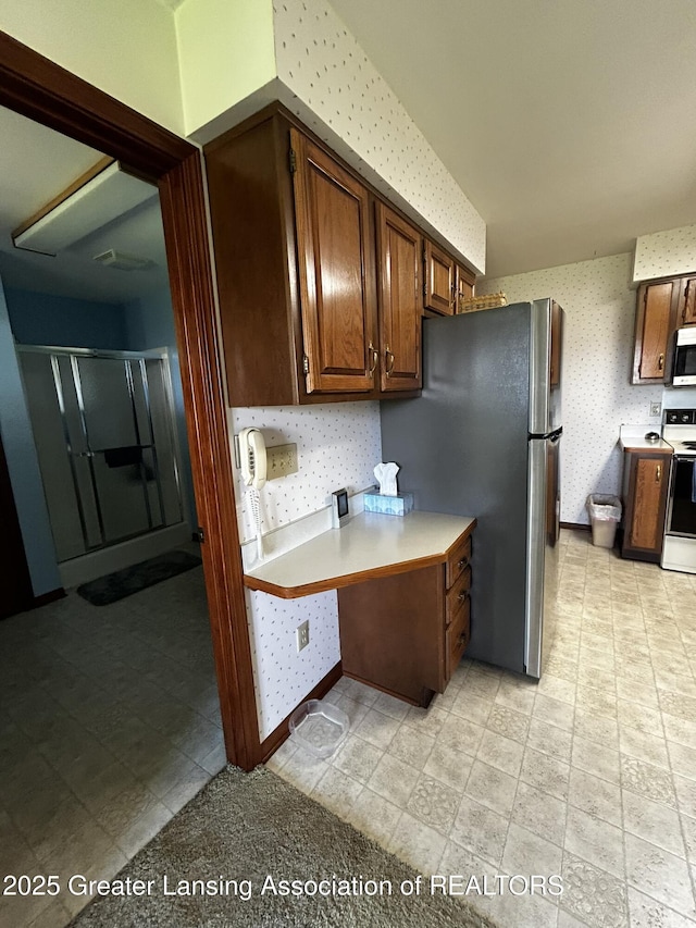 9466 W Grand River Ave, Grand Ledge, MI 48837 - kitchen featuring light countertops, freestanding refrigerator, wallpapered walls, and electric range