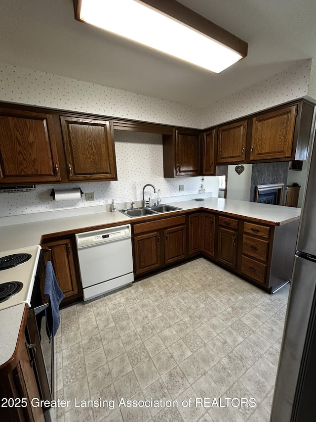 9466 W Grand River Ave, Grand Ledge, MI 48837 - kitchen with electric range oven, dishwasher, a sink, light countertops, and freestanding refrigerator