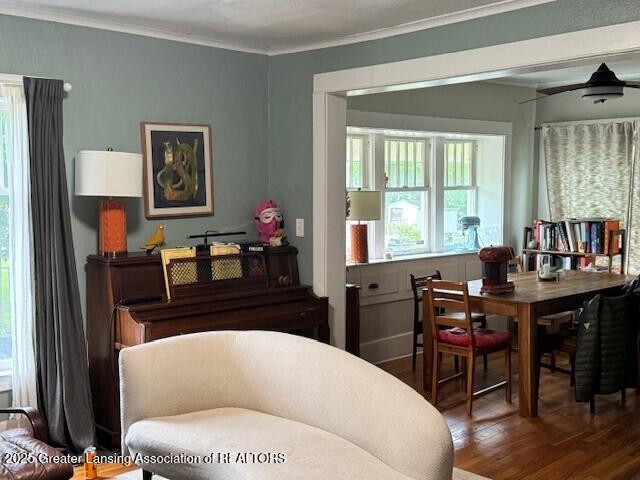 dining area with wood finished floors, crown molding, and a ceiling fan
