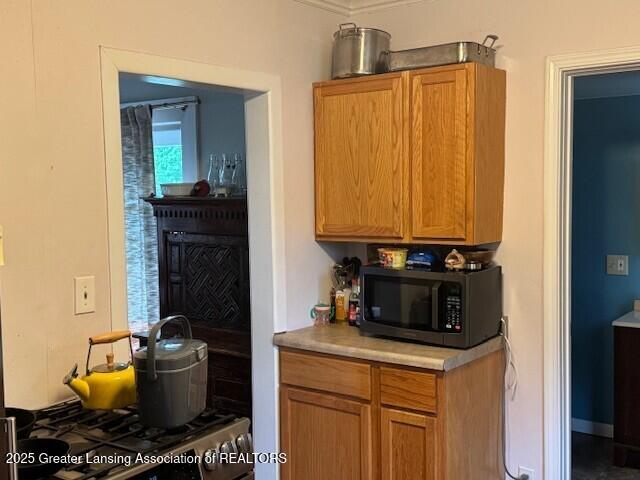kitchen with black microwave, light countertops, and brown cabinets