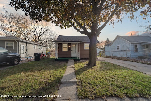 4125 Lowcroft Ave, Lansing, MI 48910 - bungalow-style home with concrete driveway, a porch, and a front yard