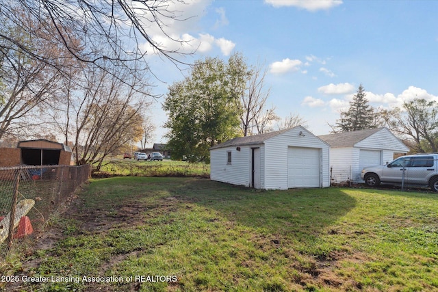 4125 Lowcroft Ave, Lansing, MI 48910 - view of yard featuring an outdoor structure, a garage, and fence