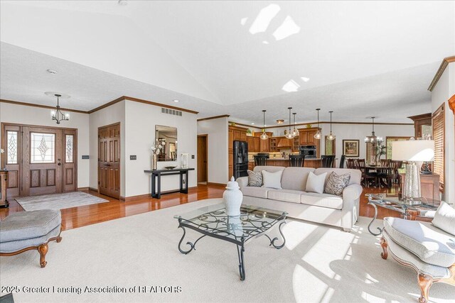 3012 Appaloosa Way, Lansing, MI 48906 - living room featuring visible vents, a chandelier, ornamental molding, and vaulted ceiling