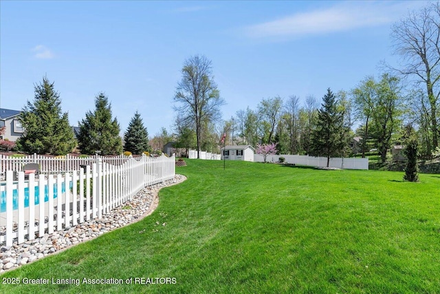 3012 Appaloosa Way, Lansing, MI 48906 - view of yard featuring fence, a storage unit, a fenced in pool, and an outbuilding