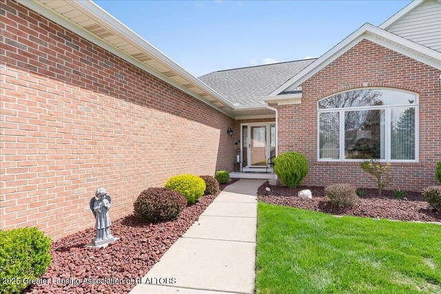 3012 Appaloosa Way, Lansing, MI 48906 - view of exterior entry featuring a yard and brick siding