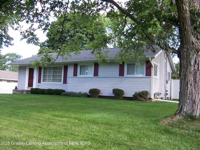 single story home with roof with shingles and a front yard