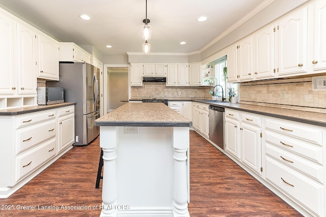 kitchen featuring stainless steel appliances, crown molding, white cabinetry, a sink, and tasteful backsplash