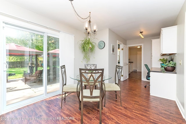 dining space featuring dark wood-style floors, baseboards, and a chandelier