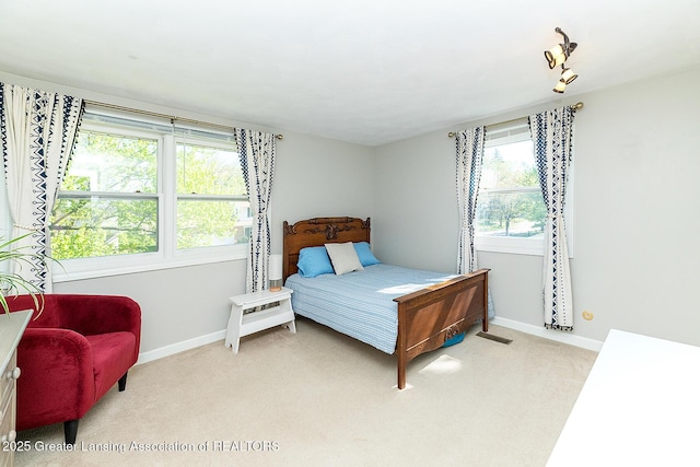 bedroom with light carpet and baseboards