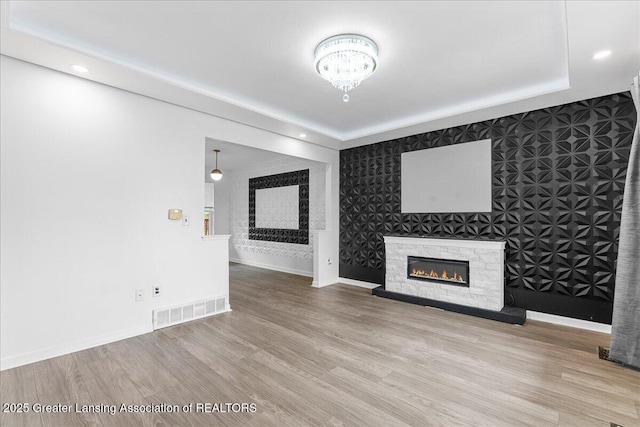 unfurnished living room featuring recessed lighting, visible vents, wood finished floors, and a fireplace