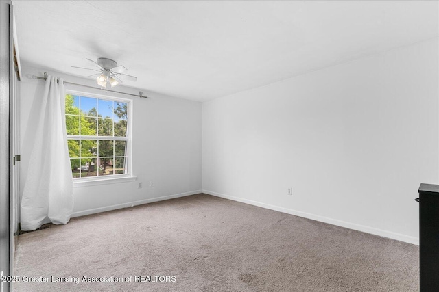 spare room with carpet floors, ceiling fan, and baseboards