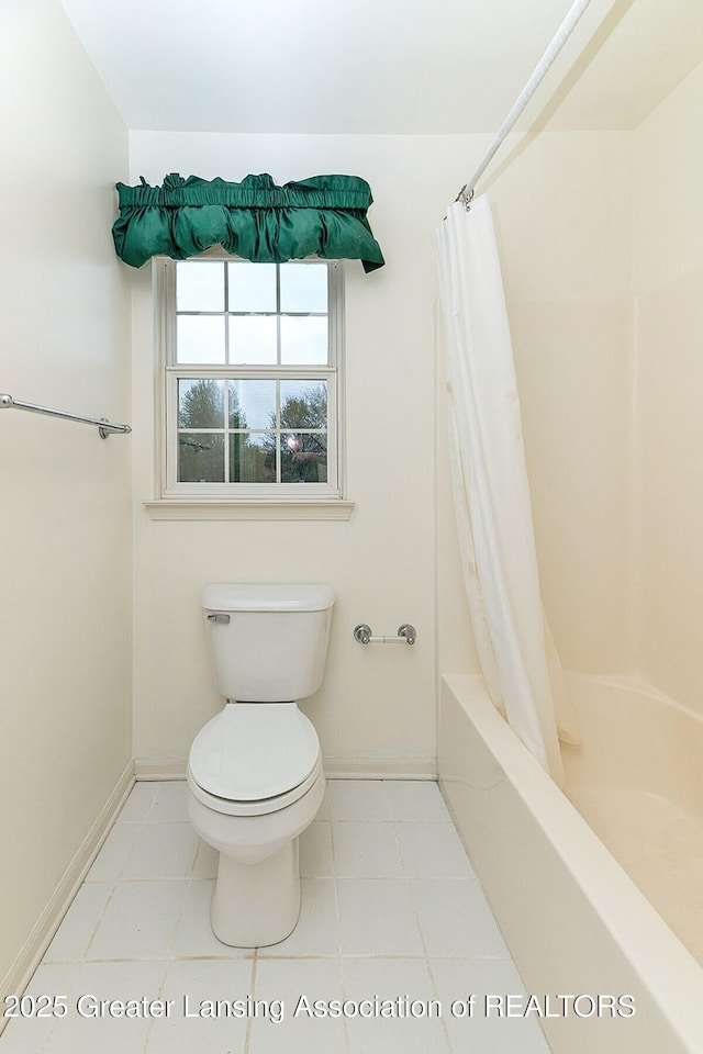 full bathroom with baseboards, shower / bath combo, and toilet