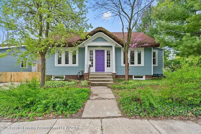 bungalow-style house with fence