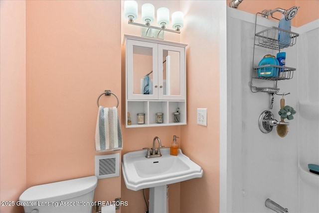 full bath with toilet, walk in shower, a sink, and visible vents