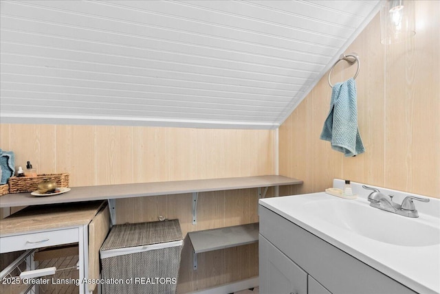 bathroom with vanity and wooden walls