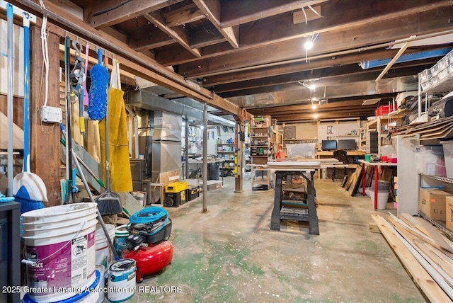 unfinished below grade area with a workshop area and heating unit