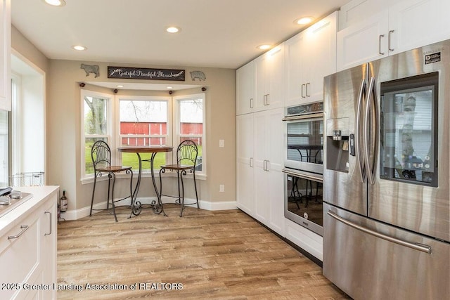 1061 E Sherwood Rd, Williamston, MI 48895 - kitchen featuring appliances with stainless steel finishes, white cabinetry, light wood finished floors, recessed lighting, and baseboards