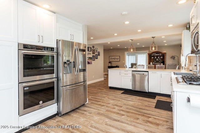 1061 E Sherwood Rd, Williamston, MI 48895 - kitchen featuring stainless steel appliances, a peninsula, a sink, white cabinets, and recessed lighting