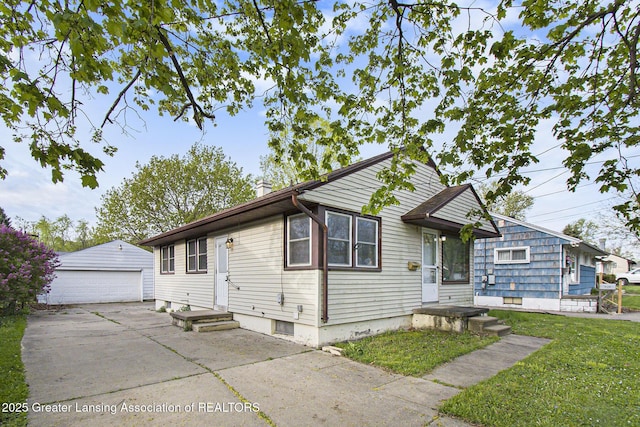 bungalow with a front lawn, an outdoor structure, and a garage