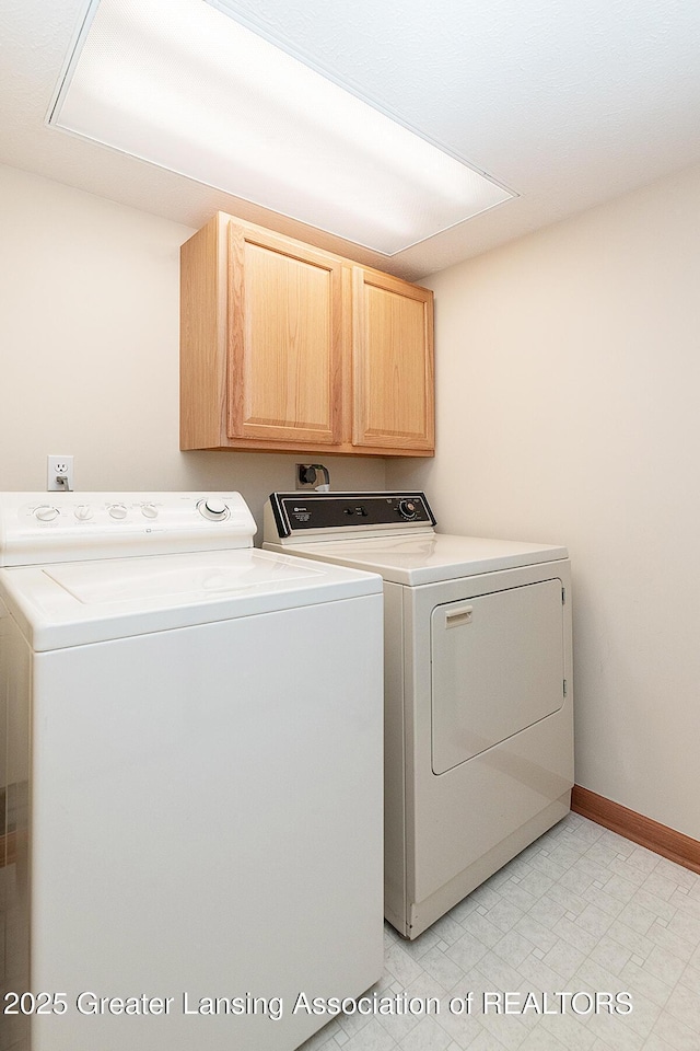 6032 Vienna Way, Lansing, MI 48917 - clothes washing area featuring light floors, washer and clothes dryer, cabinet space, and baseboards
