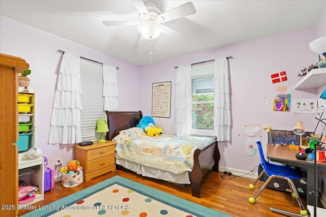 bedroom featuring a ceiling fan, wood finished floors, and baseboards