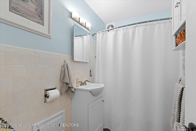 full bathroom with vanity, tile walls, and a shower with curtain