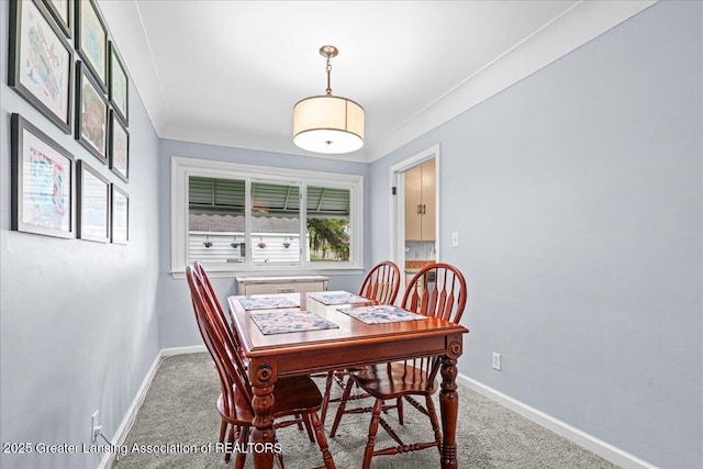 carpeted dining room with baseboards