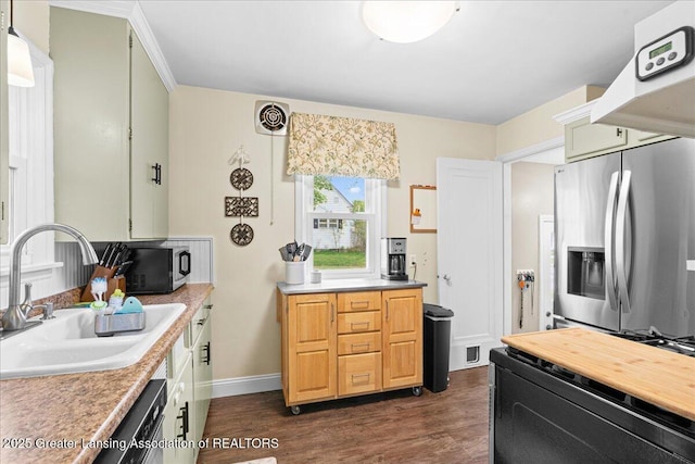 kitchen with baseboards, a sink, dark wood-type flooring, light countertops, and appliances with stainless steel finishes