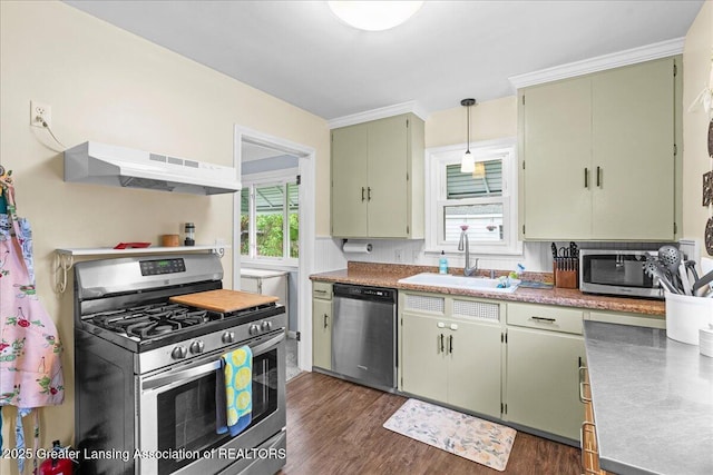 kitchen with a sink, stainless steel appliances, dark wood-type flooring, green cabinets, and under cabinet range hood