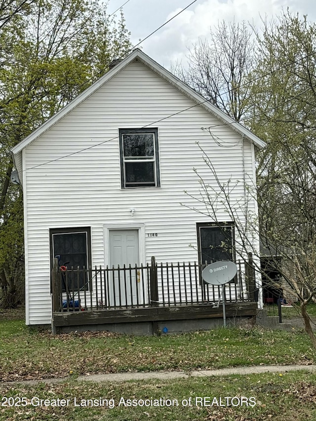rear view of house featuring a wooden deck
