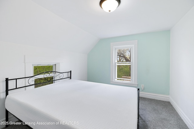 carpeted bedroom featuring lofted ceiling and baseboards