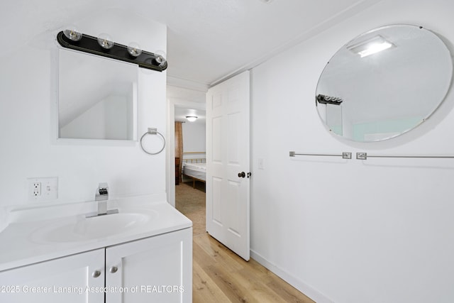 bathroom featuring baseboards, wood finished floors, and vanity
