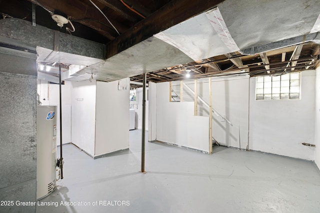 basement featuring water heater and washer / clothes dryer
