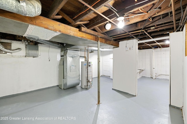 unfinished below grade area with electric panel, heating unit, and gas water heater