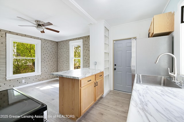 kitchen featuring a sink, light brown cabinets, ceiling fan, light countertops, and light wood-style floors
